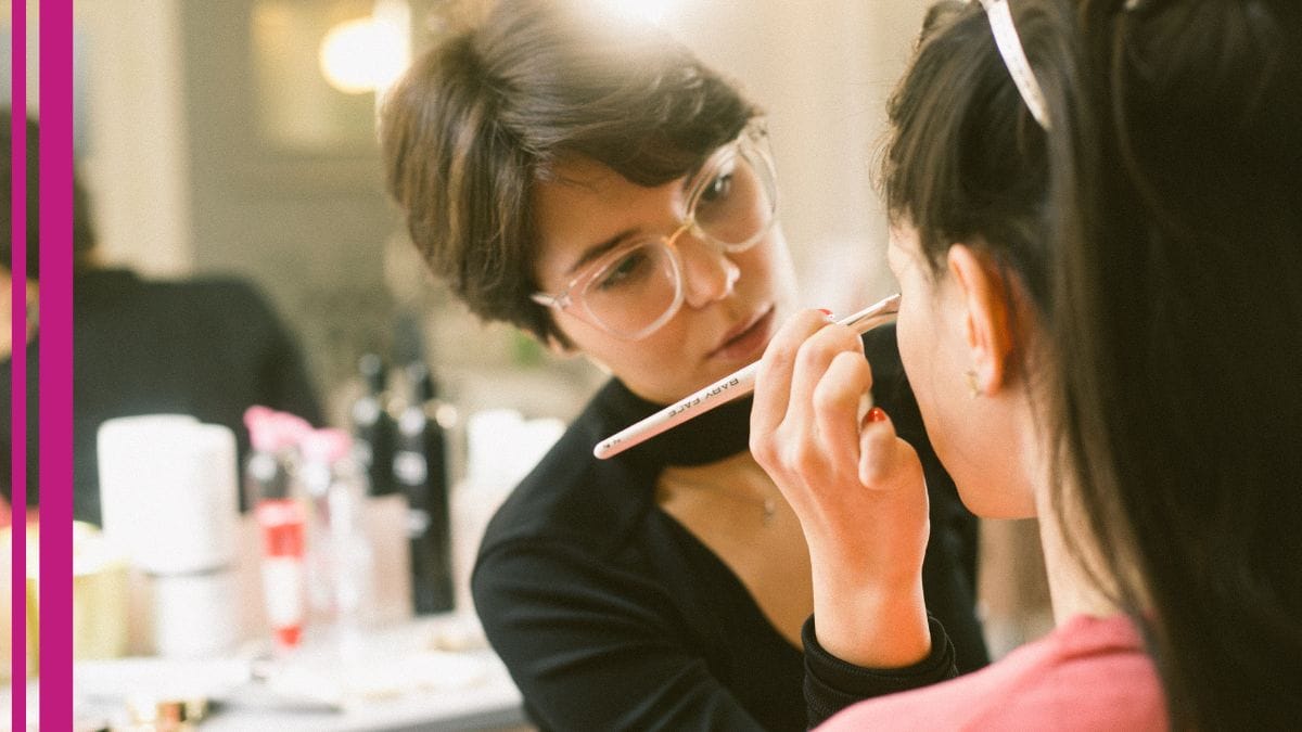 A freelance makeup artist adds eye shadow to her client's face.