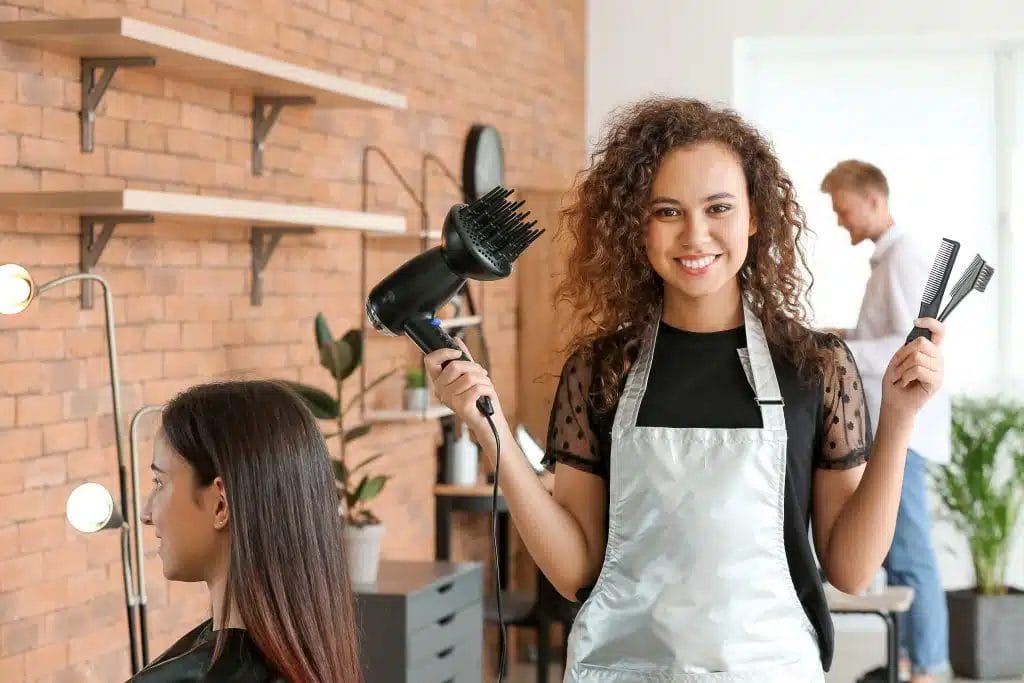 Young African-American hairdresser in beauty salon