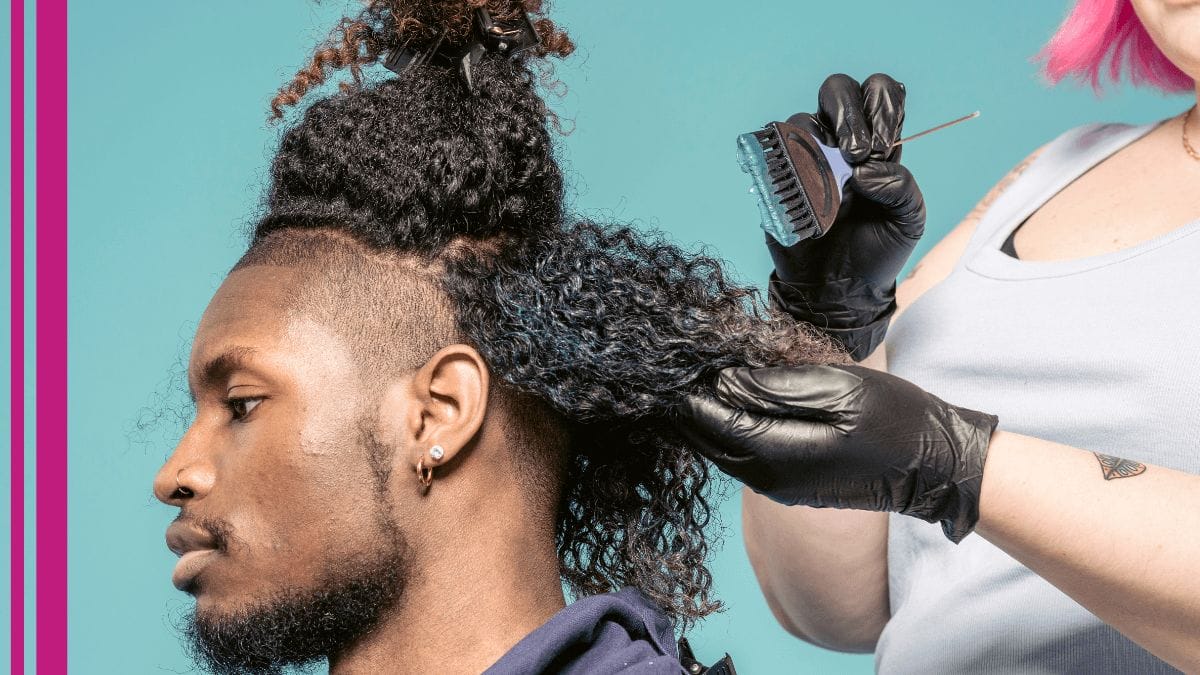 A mobile stylist works on dyeing her client's hair in his home.