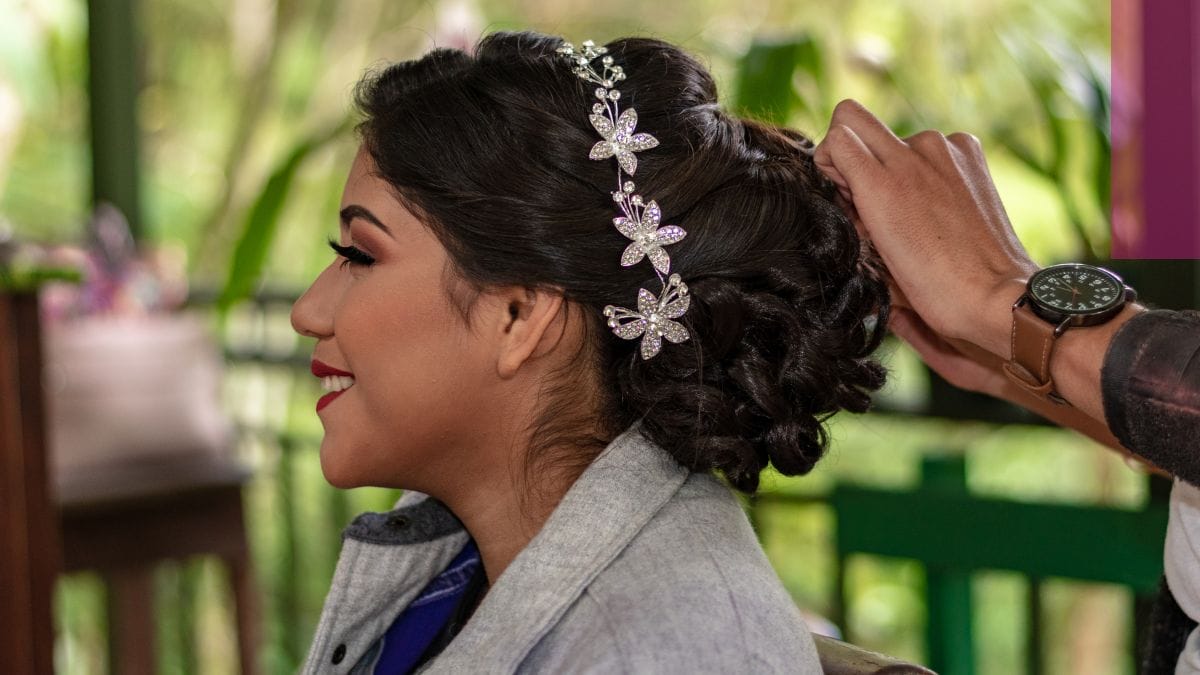 A bride gets her hair done on her big day by her bridal stylist.