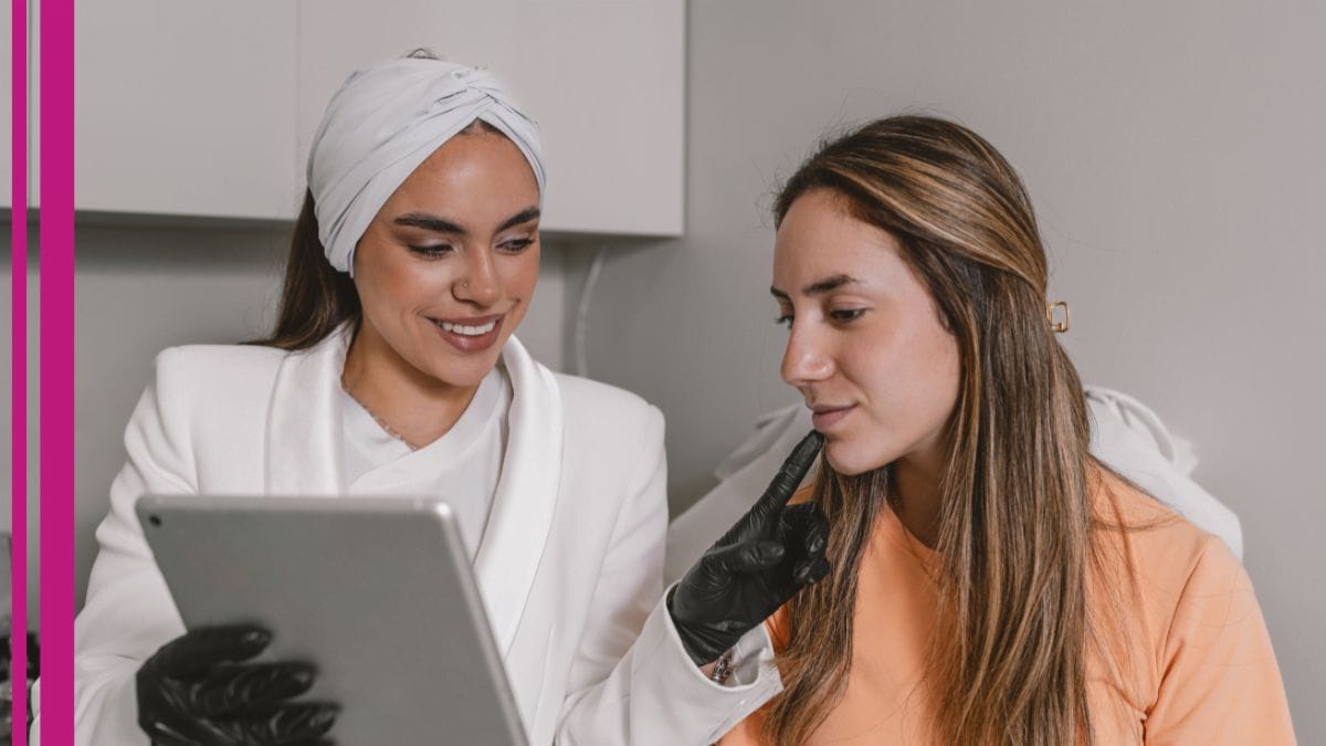 An esthetician walks her client through a procedure on her tablet.