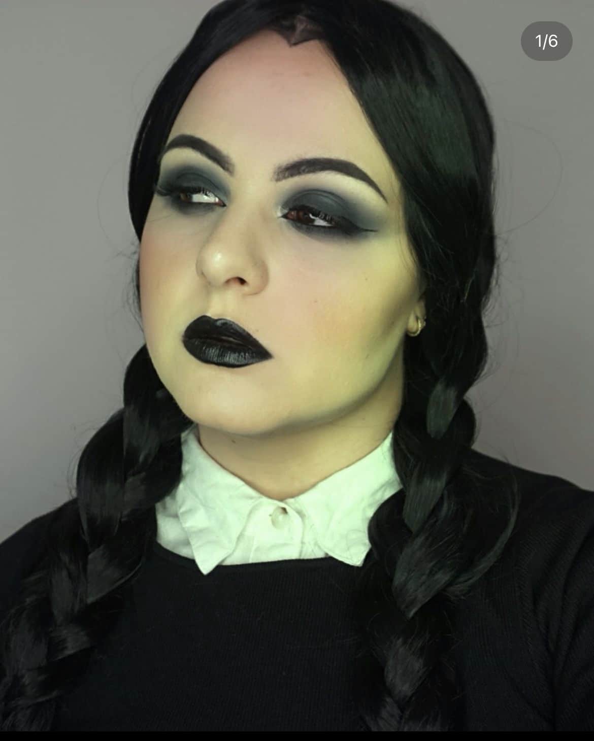 Wednesday Addams-inspired look showcasing halloween makeup trends with dark smoky eyes, black lipstick, and braided hair.