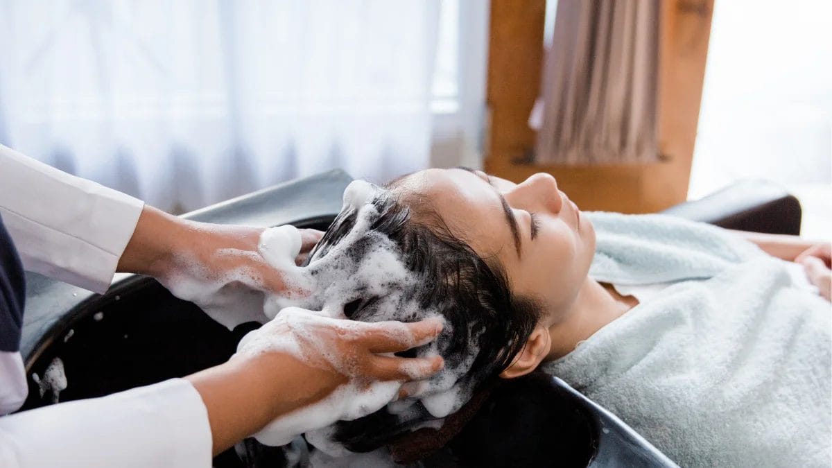 A stylist gives her client a free shampoo, one of the rewards on the loyalty program.