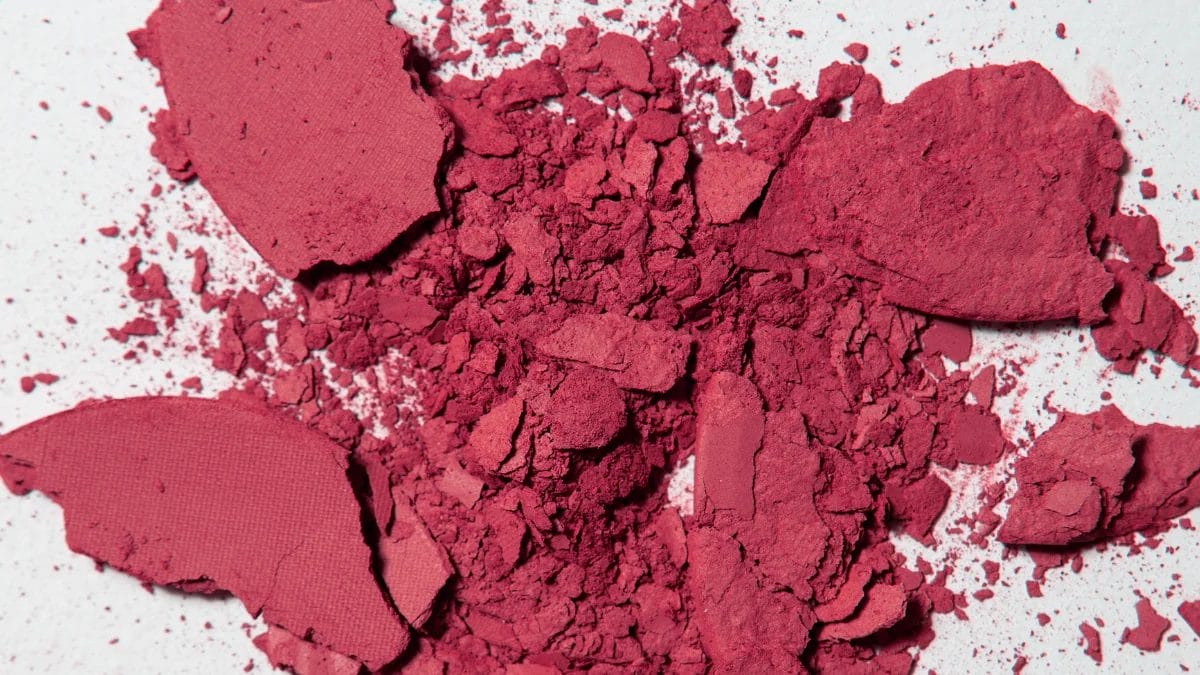 Hot pink barbie blush, a fall beauty trend, is broken all over a surface.