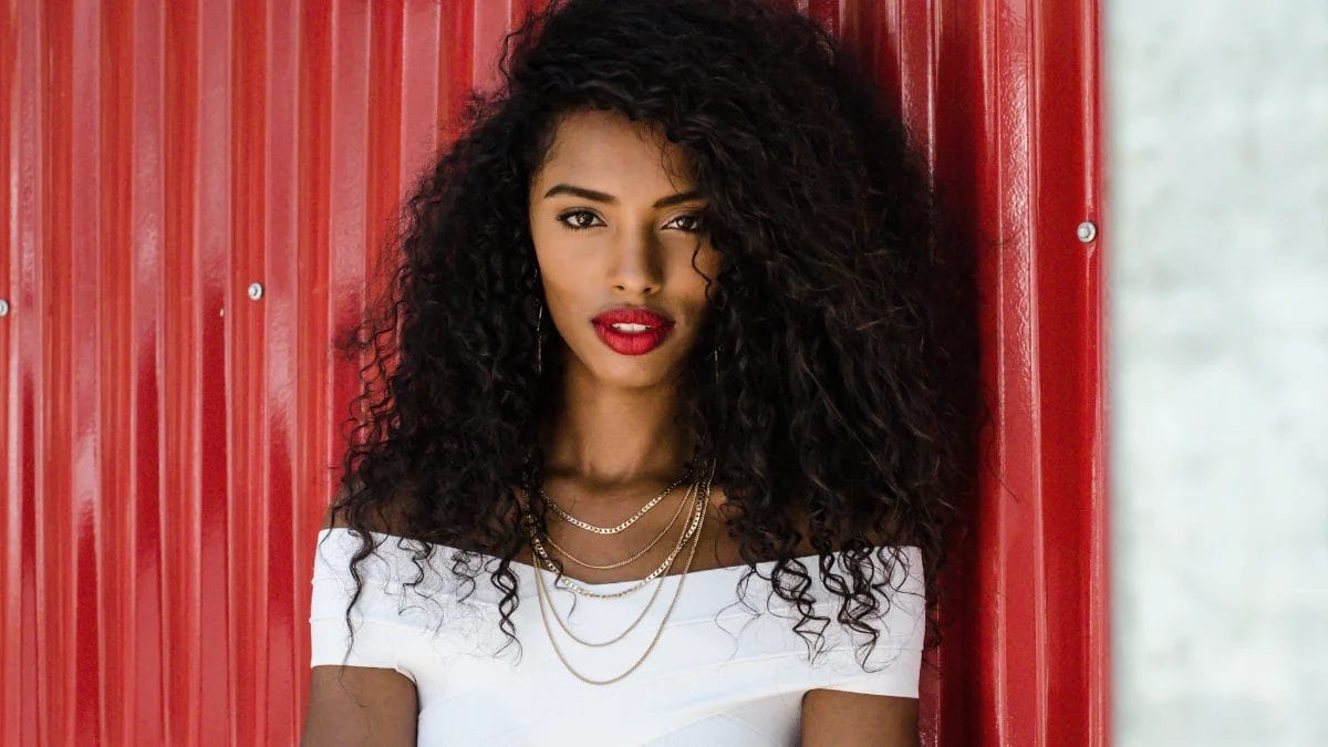 A woman shows off her red lipstick–– blood red lips are a Fall beauty trend.