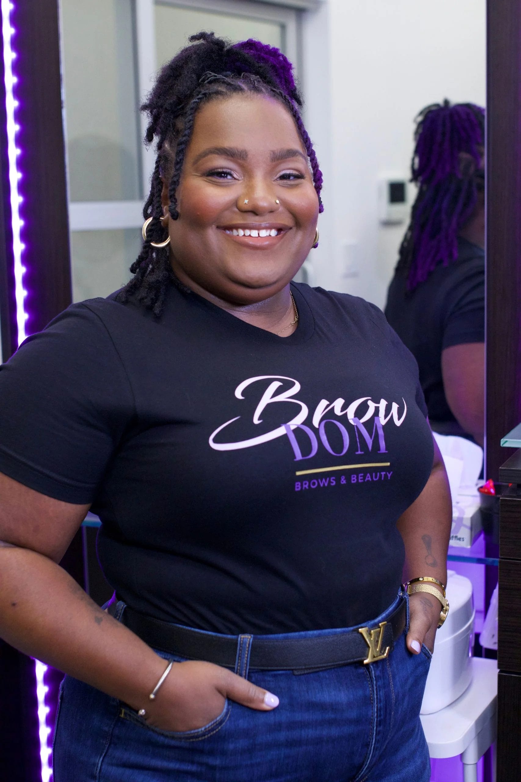 Black beauty pro Dominique poses with her company's logo on her t-shirt.