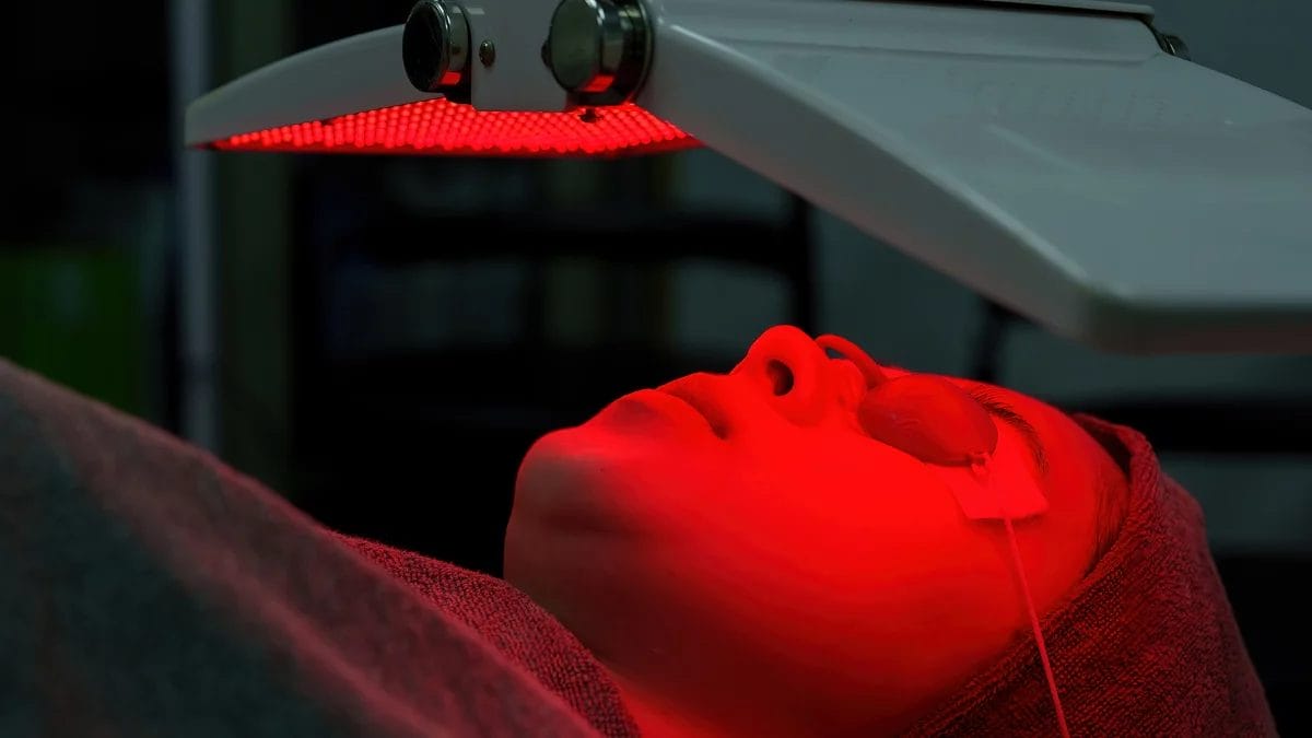 A client gets an LED light therapy treatment from her cosmetologist.