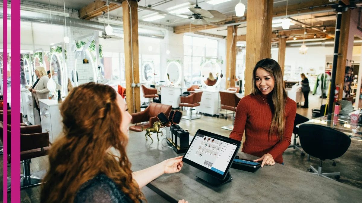 A client stops in to a beauty business and checks out at the service desk after receiving a small business week promo.