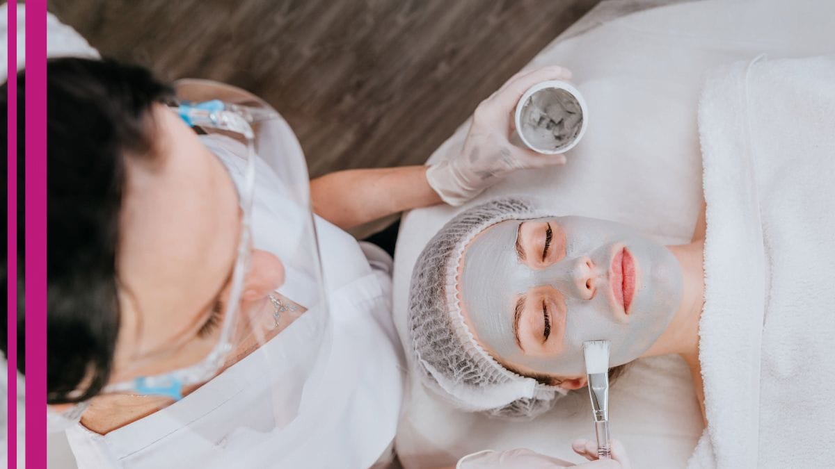 An esthetician layers a facial on her client as she learns new tips on how to grow her esthetician business.