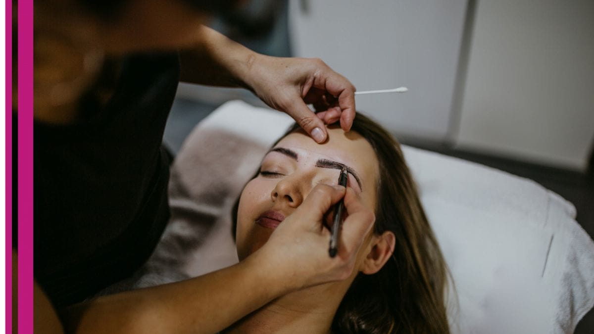 A freelance beauty professional shapes her client's eyebrows.