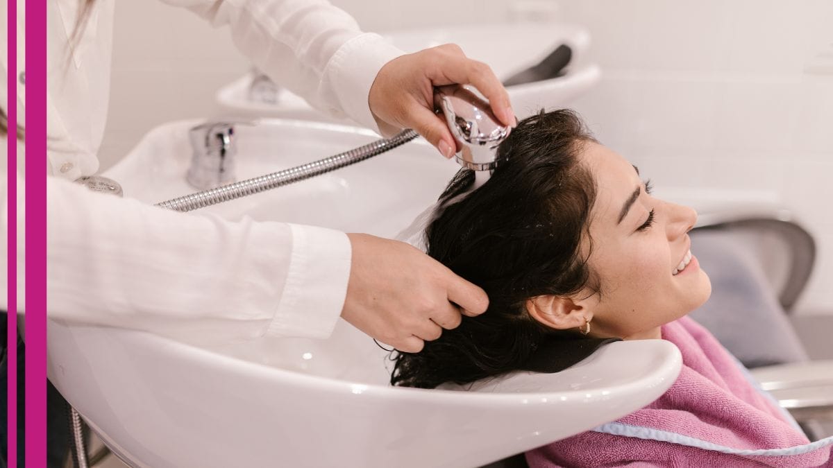 A client gets her hair washed by her stylist during hair stylist appreciation month.