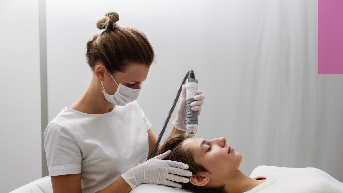 An esthetician wears a mask and works on her client's microneedling treatment.