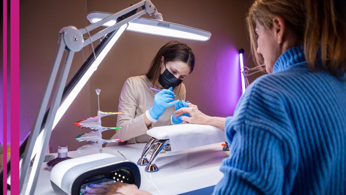 A client gets her nails done by a student in her nail technician program.