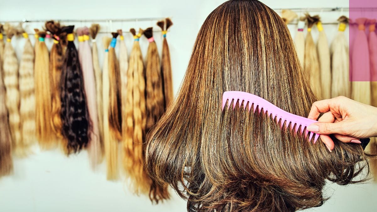 A stylist combs through her client's wig hair, maintaining them this way is a successful wig stylist business tip.