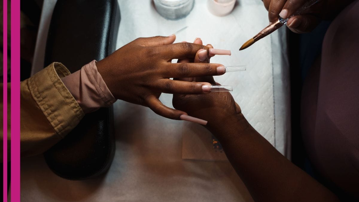 A nail tech fixes her client's DIY nails at her salon.