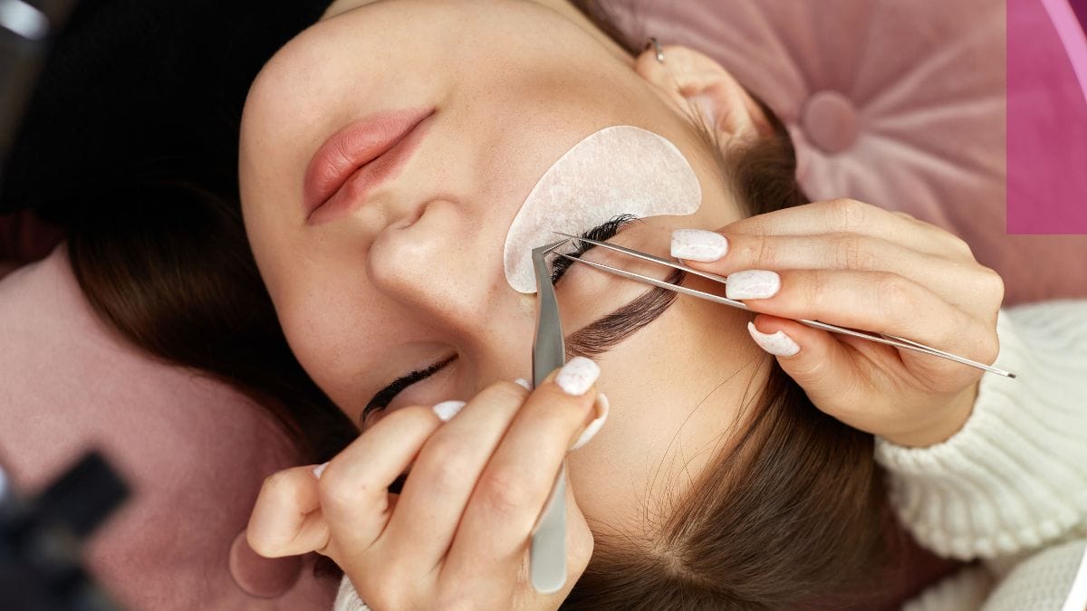 A client gets eyelash extensions applied by her go-to cosmetologist.