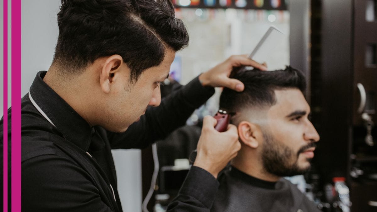 A barber trims his clients hair while discussing seo tips for small businesses