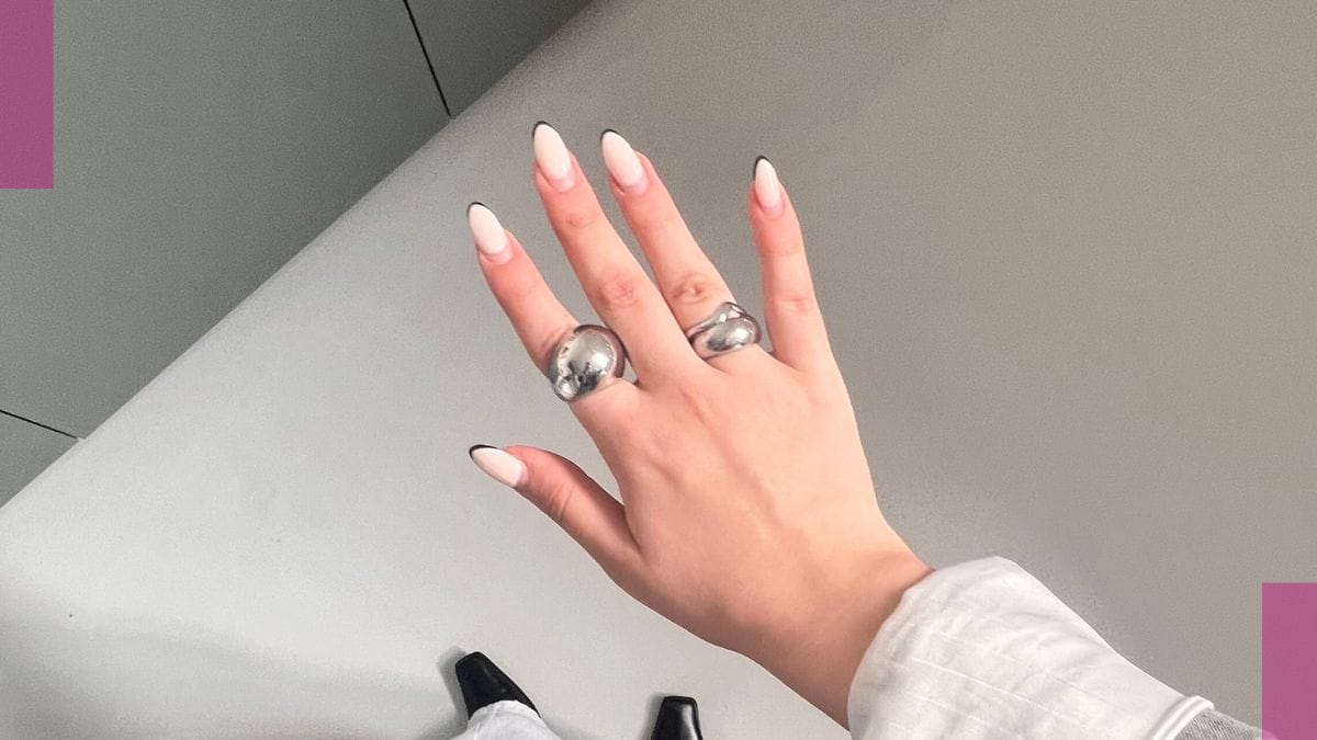 A client shows off her spring break nails with a black french tip design