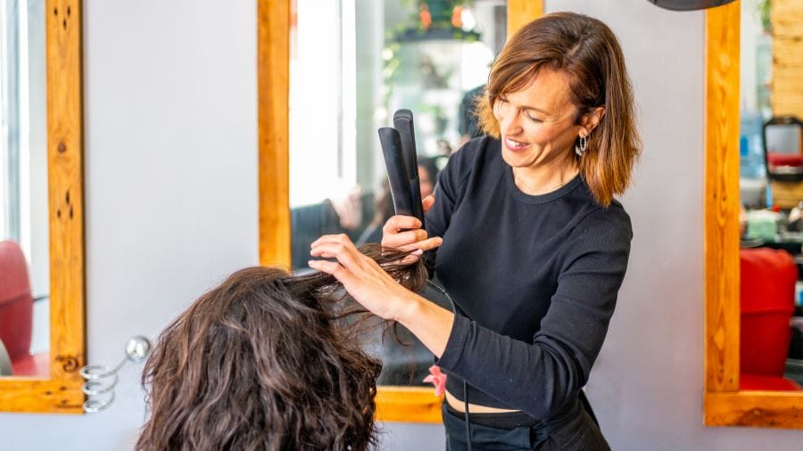 a hairstylist styles her client's hair as a complimentary add-on treatment to show her appreciation