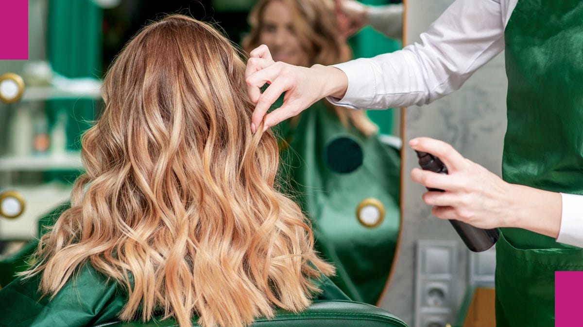 A stylist helps her client with a salon treatments for curly hair.